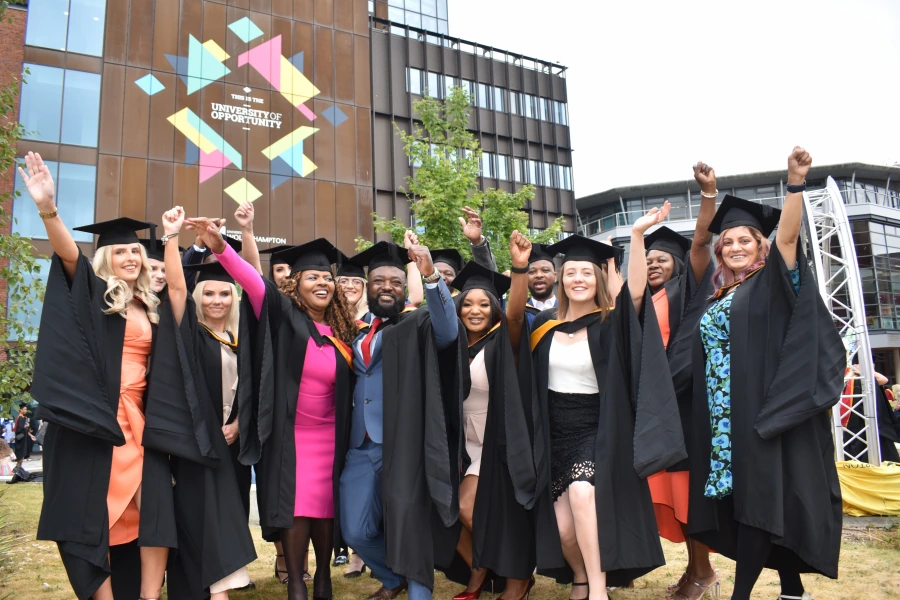 Graduates celebrating outside a university campus